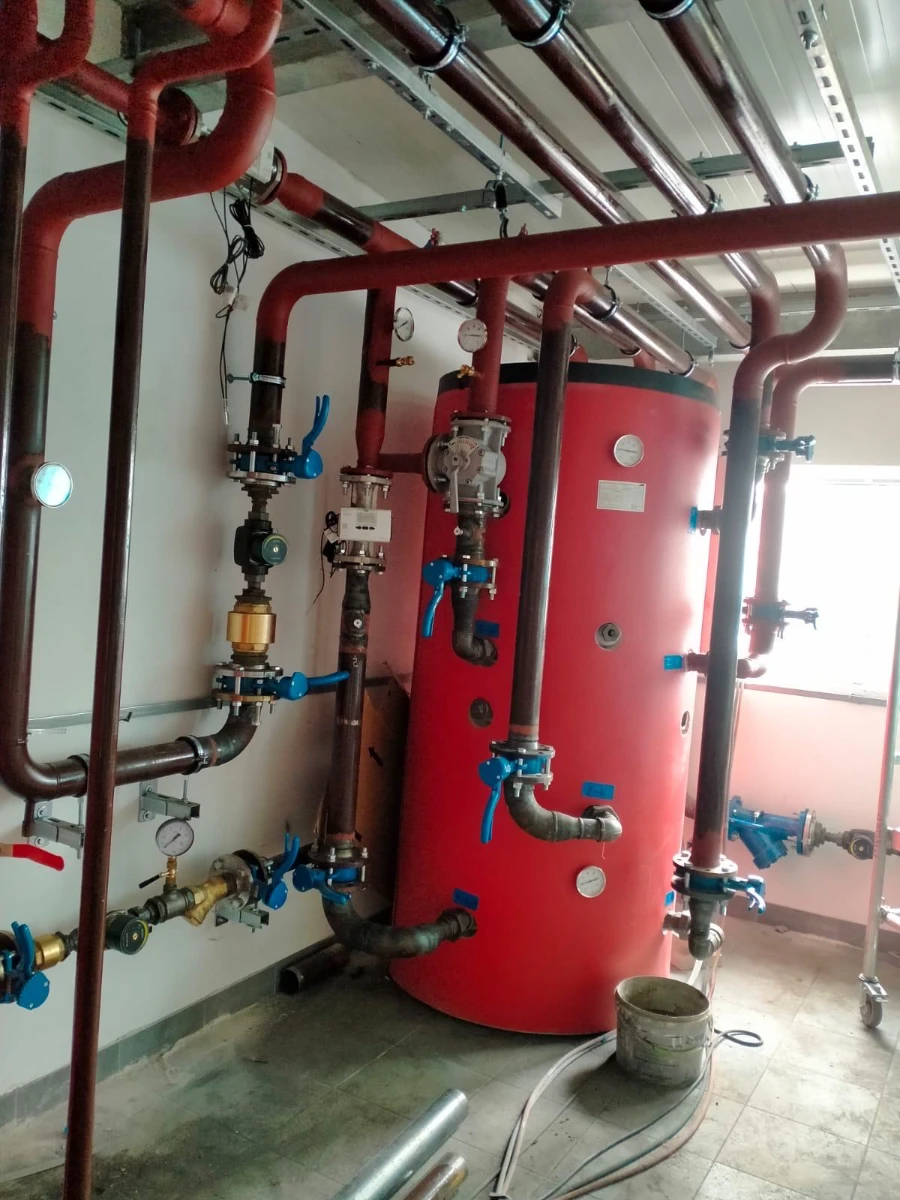Instalacja CO kotłownia z czerwonym zbiornikiem buforowym i siecią rur z zaworami